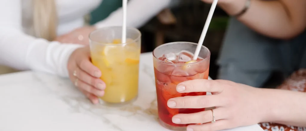 Twee vriendinnen met drankjes aan tafel
